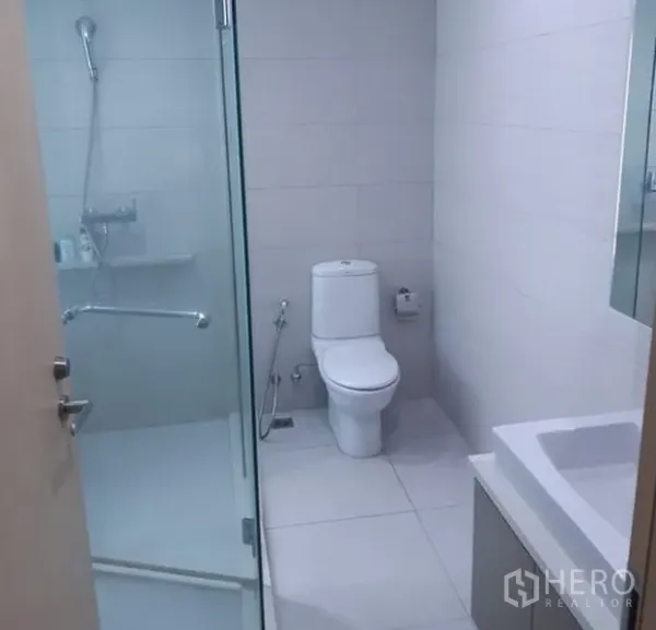 คอนโด ให้เช่าในKhlong Toei, Bangkok - ห้องน้ำสว่างพร้อมตู้กระจกกั้นอาบน้ำ กระเบื้องสีขาว และโถสุขภัณฑ์