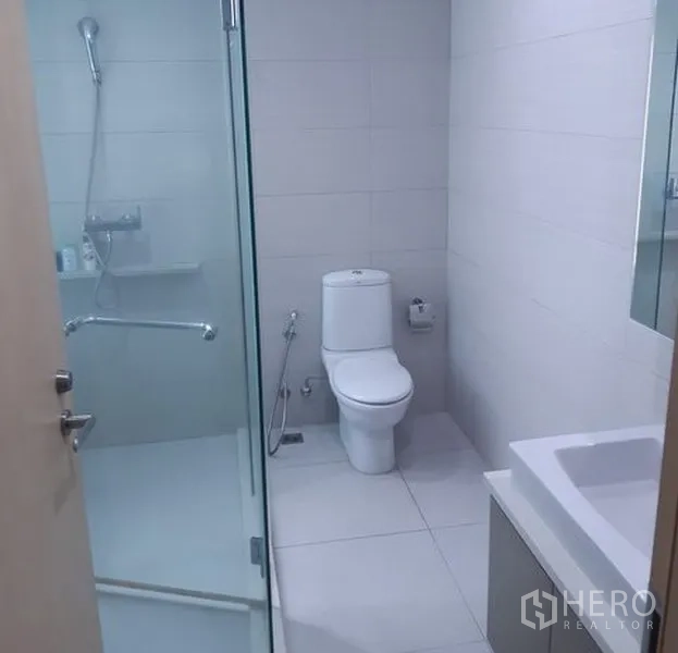 คอนโด ให้เช่าในKhlong Toei, Bangkok - ห้องน้ำสว่างพร้อมตู้กระจกกั้นอาบน้ำ กระเบื้องสีขาว และโถสุขภัณฑ์