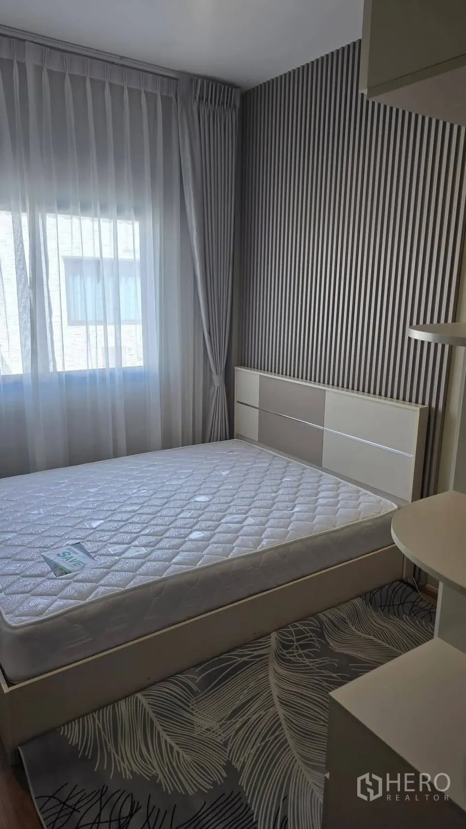 Townhouse for rent in Bang Phli, Samut Prakan - Bedroom featuring a striped accent wall and platform bed by the window.