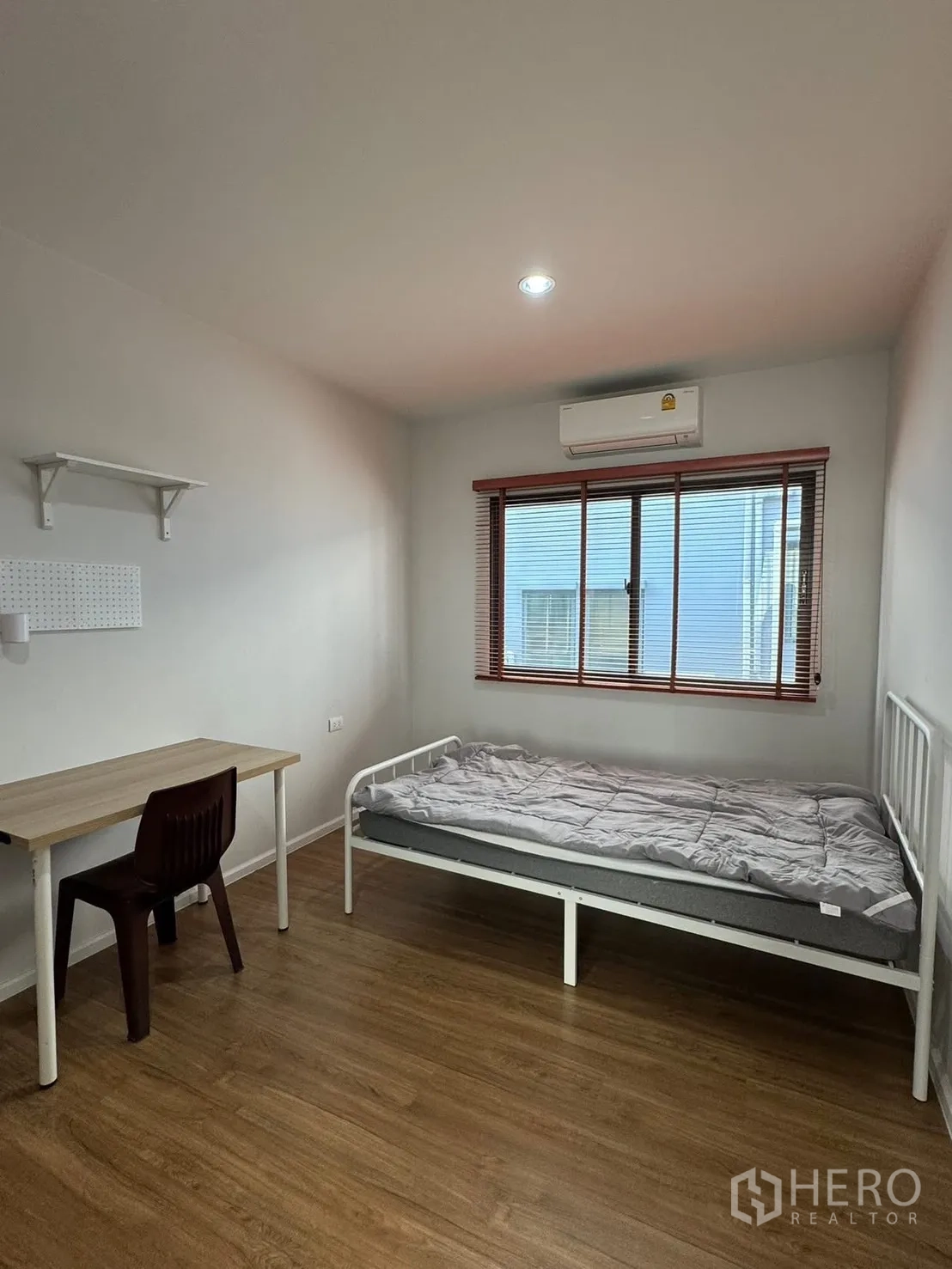 Townhouse for rent in Saphan Sung, Bangkok - Secondary bedroom with single bed, desk, AC and window blinds.