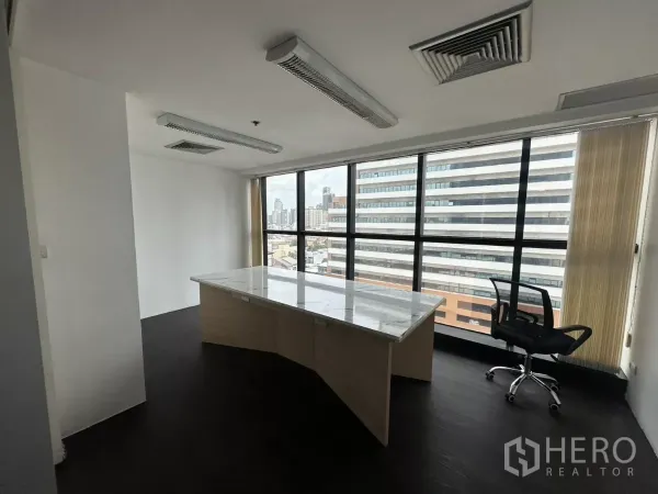 办公空间 出租在Watthana, Bangkok - 转角独立办公室，岩板桌面，落地窗眺望天际线。