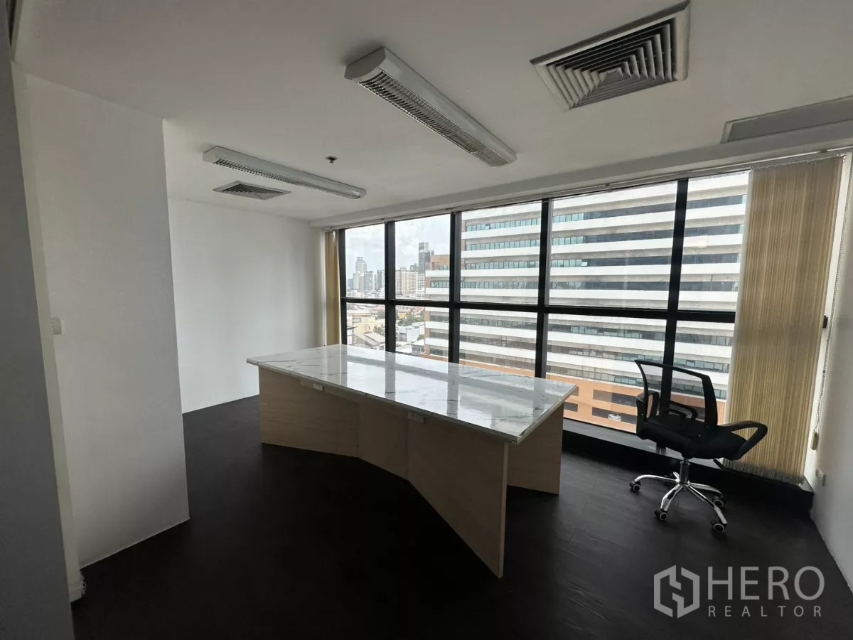 办公空间 出租在Watthana, Bangkok - 转角独立办公室，岩板桌面，落地窗眺望天际线。