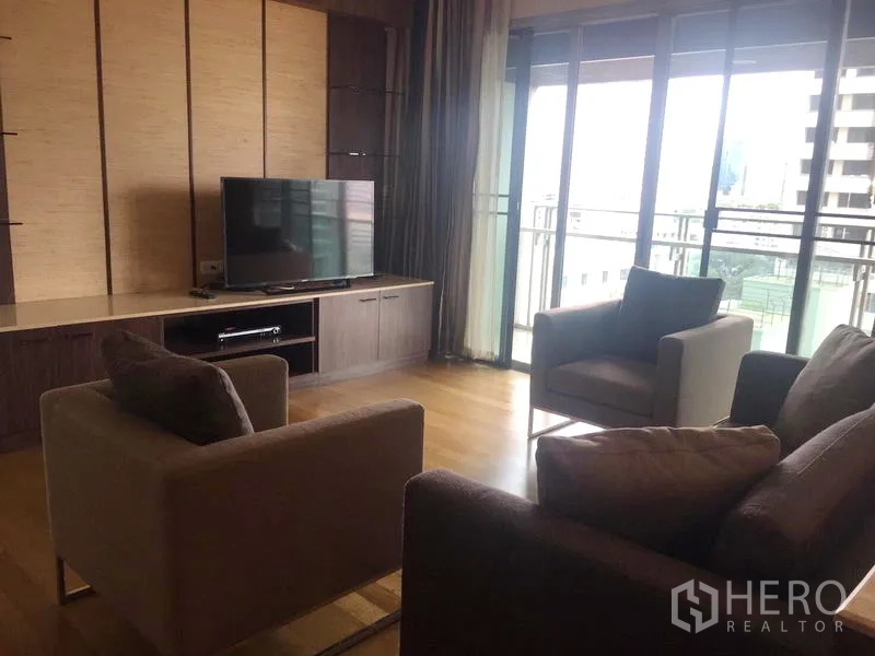 คอนโด ให้เช่าในWatthana, Bangkok - ห้องนั่งเล่นโปร่งพื้นไม้ ผนังทีวีบิวท์อิน ประตูกระจกเปิดสู่ระเบียง