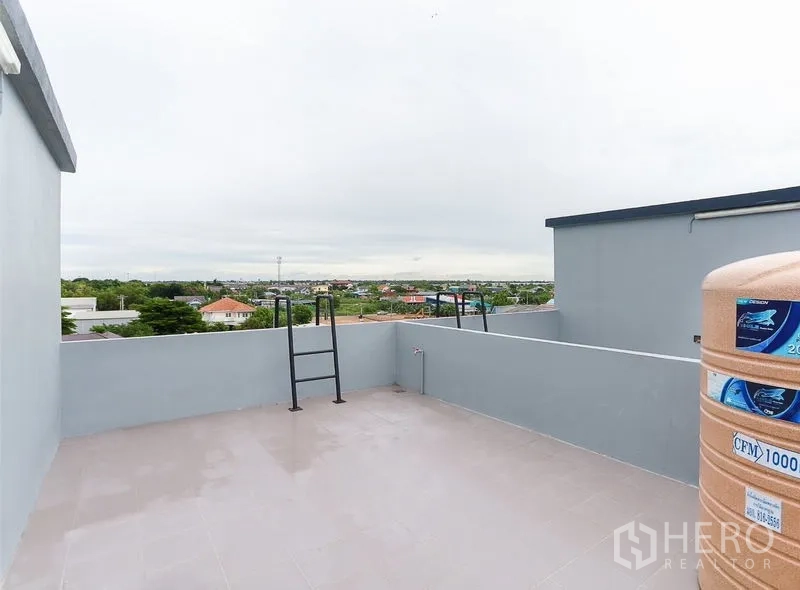 Shophouse for sale in Lam Luk Ka, Pathum Thani - Rooftop terrace with city views and a water tank on the shophouse roof.