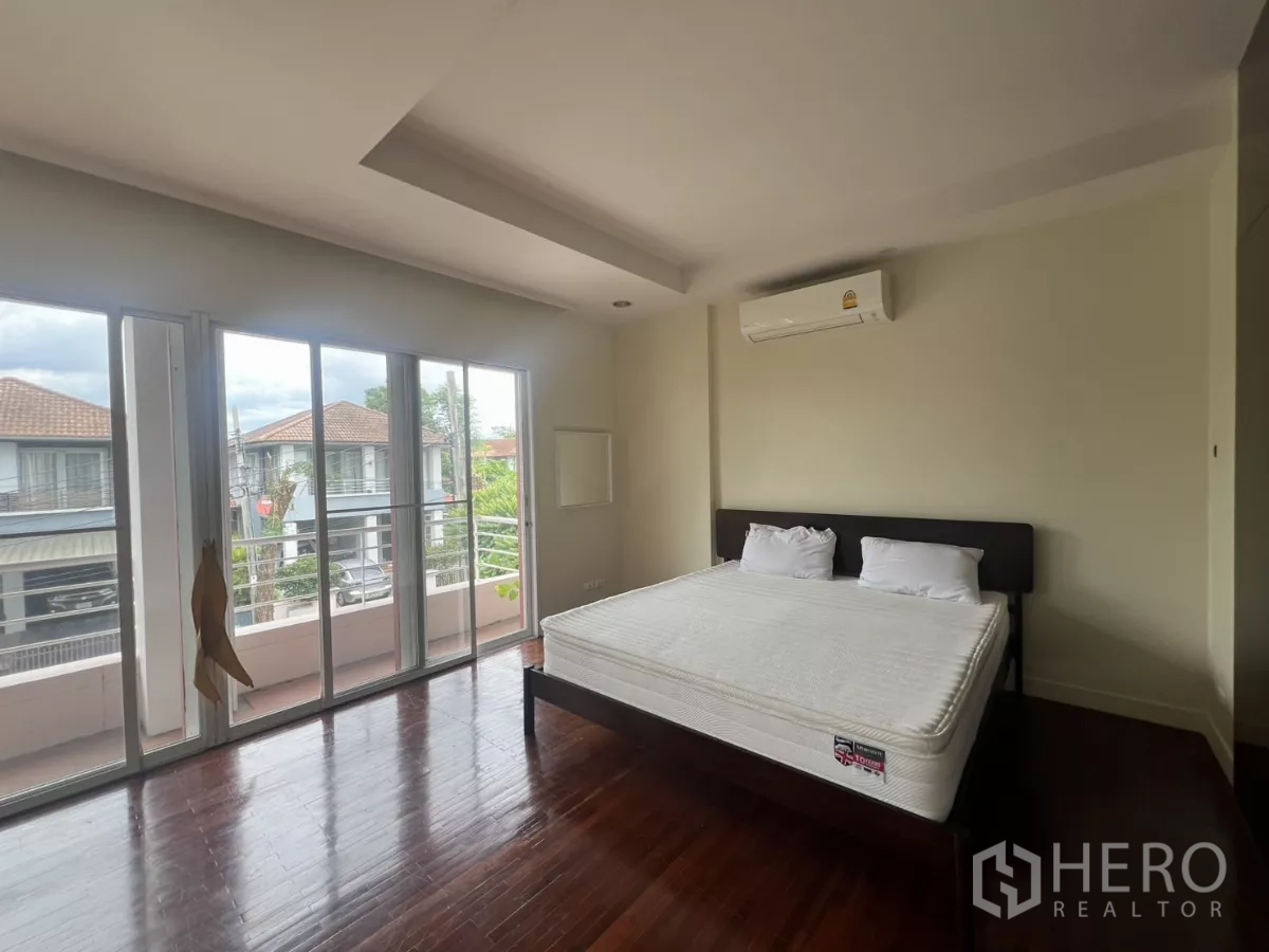 บ้าน ให้เช่าในWang Thonglang, Bangkok - ห้องนอนหลักกว้าง มีระเบียง พื้นไม้ และเครื่องปรับอากาศ