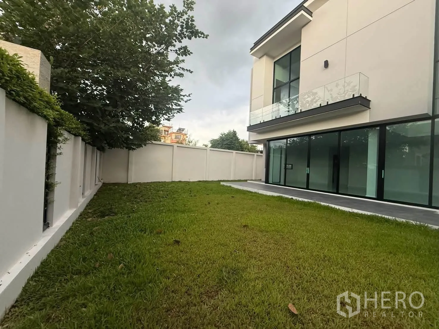 บ้านเดี่ยว for rent in Bang Khen, Bangkok - สนามหญ้าหลังบ้านและด้านหลังบ้านสมัยใหม่พร้อมระเบียง