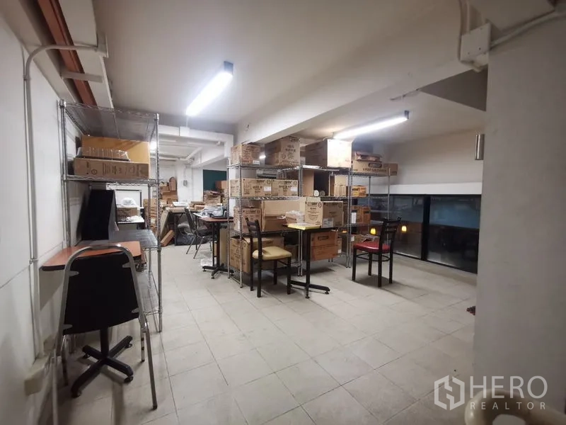 店屋 出租在Bangkok - 夹层仓储间，金属置物架、纸箱与工作桌。