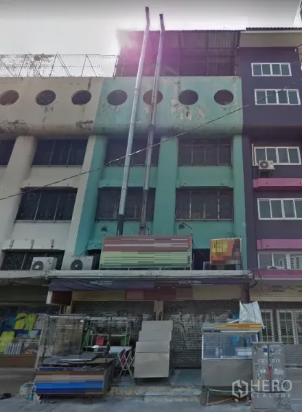 店屋 出租在Ratchathewi, Bangkok - 多层店屋立面，薄荷绿色外墙，卷闸门与遮阳篷，双排排气管，位于曼谷拉差贴威BTS附近。