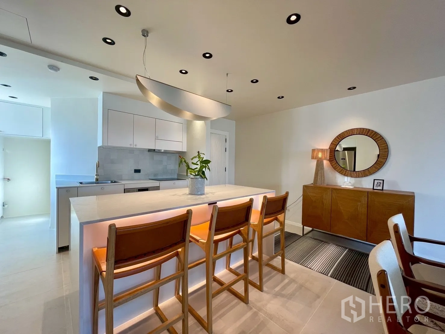 Condominium for sale in Watthana, Bangkok - Contemporary kitchen island with bar stools and sleek cabinetry.