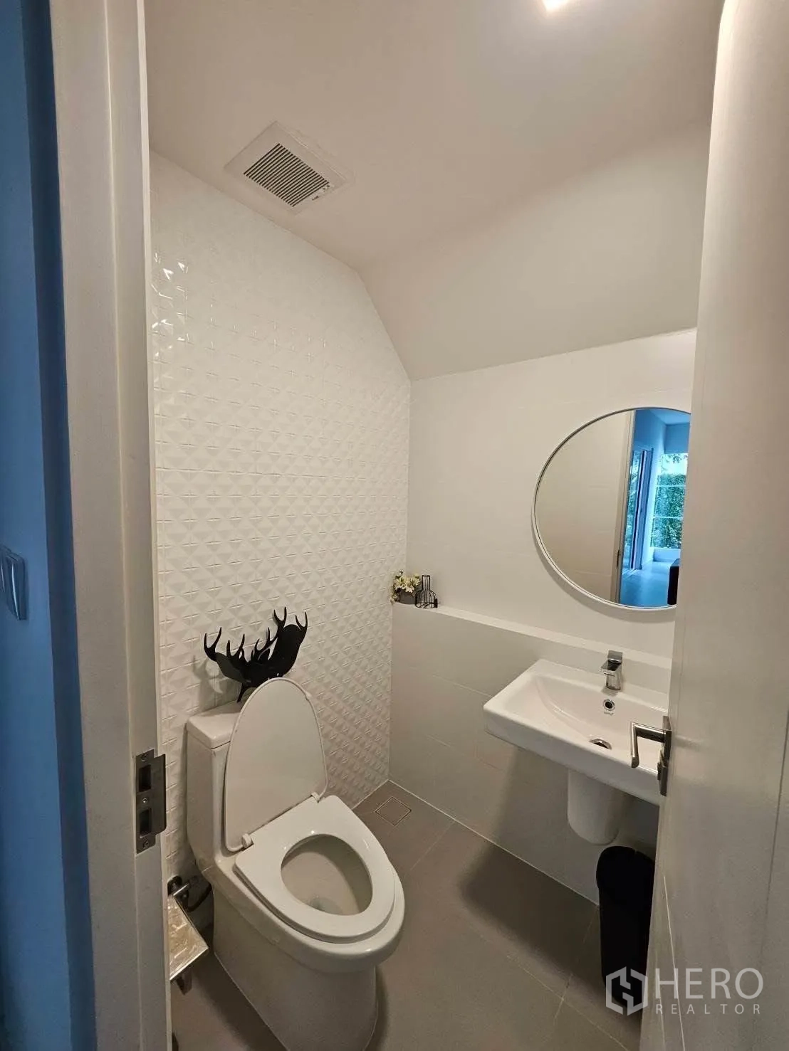 บ้านเดี่ยว for rent in Bang Phli, Samut Prakan - ห้องน้ำสไตล์โมเดิร์นขนาดกะทัดรัด ผนังลายเท็กซ์เจอร์ กระจกกลม อ่างล้างหน้าแขวน และโถสุขภัณฑ์