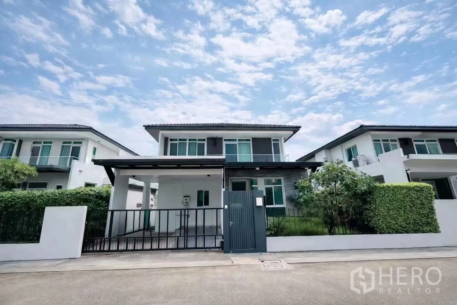 Detached House for rent or sale in Bang Phli, Samut Prakan - Contemporary two-storey house exterior with gated carport and front lawn.