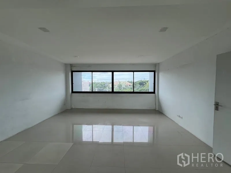 Warehouse for rent in Bang Phli, Samut Prakan - Long rectangular office with wide horizontal windows overlooking greenery and the street.