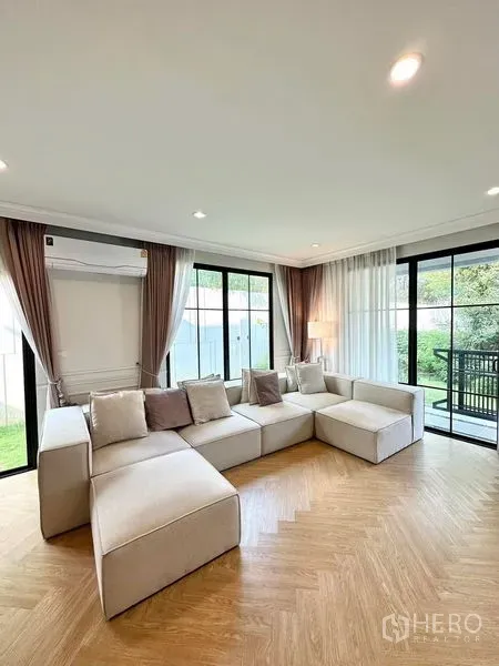 Detached House for sale in Prawet, Bangkok - Corner lounge with floor-to-ceiling sliding glass doors opening to garden views.
