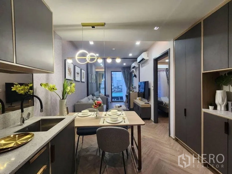 Condominium for rent in Bang Rak, Bangkok - Compact kitchen and dining area looking toward the living room and balcony views.