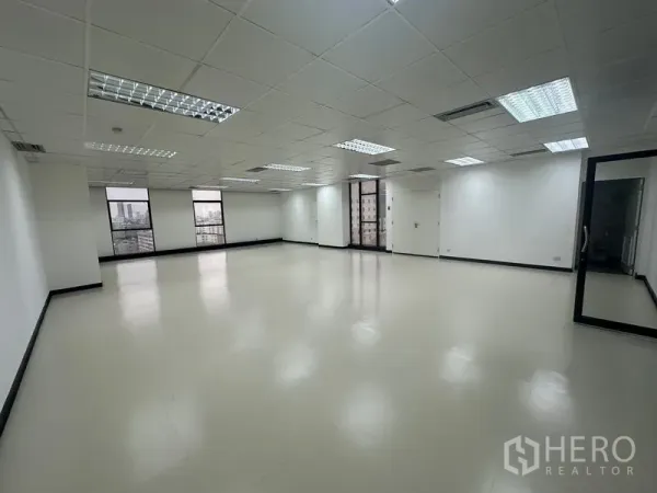 สำนักงาน ให้เช่า - ชั้นสำนักงานกว้างโล่ง พื้นสะอาด หน้าต่างหลายบาน ประตูกระจก และฝ้าฉาบเรียบพร้อมโคมไฟ