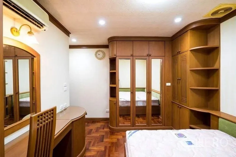 公寓 出租或出售在Bang Phlat, Bangkok - 客卧带弧形整体书架、学习桌与镜面衣柜。