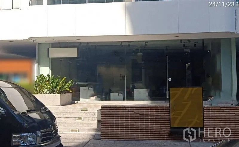 零售空间 出租在Watthana, Bangkok - 商铺外观，带台阶、绿植花槽、宽阔门面及街边指示牌。