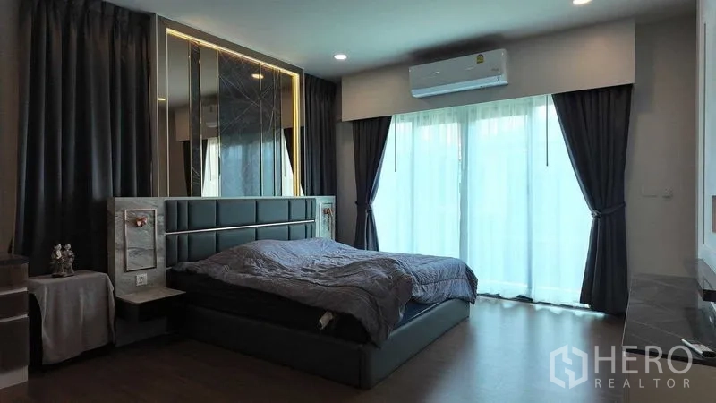 บ้าน ให้เช่าหรือขายในBang Na, Bangkok - ห้องนอนใหญ่พร้อมหัวเตียงบุนวม ผ้าม่านทึบ และประตูบานเลื่อนออกระเบียง