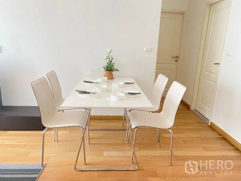 คอนโด ให้เช่าในBangkok - มุมทานอาหารสว่างโปร่ง โต๊ะขาวรองรับสี่ที่นั่ง พื้นไม้โทนอ่อน