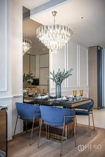 คอนโด ให้เช่าในPathum Wan, Bangkok - มุมรับประทานอาหารใต้โคมระย้าคริสตัลหลายชั้น ข้างผนังกระจก