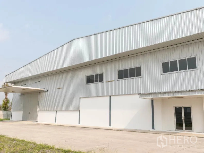 工厂 出租在Si Racha, Chon Buri - 厂房正立面，带装卸雨棚与卷帘大门