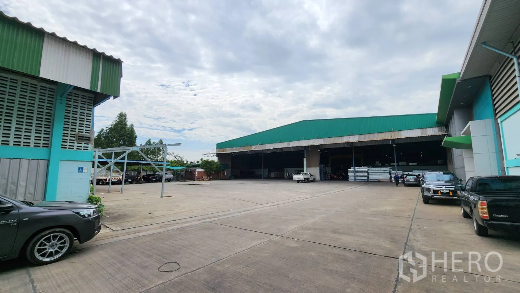 Warehouse for rent in Krathum Baen, Samut Sakhon - Industrial compound with a broad concrete apron, parking, and multiple loading bays.
