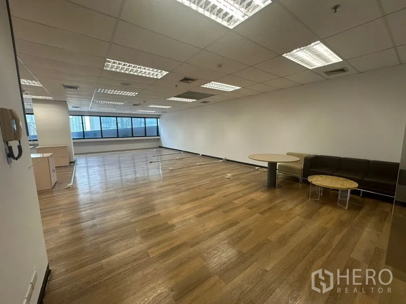 办公空间 出租在Bang Rak, Bangkok - 开放式办公室，木地板、吊顶灯和城市景观窗，位于曼谷邦拉区。