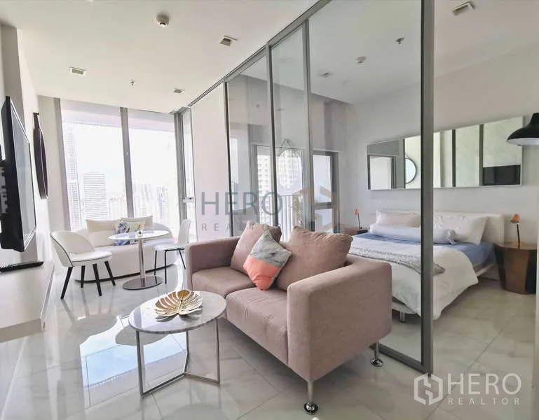 คอนโด ให้เช่า - ห้องนั่งเล่นสว่าง พร้อมโซฟาและฉากกั้นกระจกแยกห้องนอน วิวเมือง ที่ HYDE สุขุมวิท 11