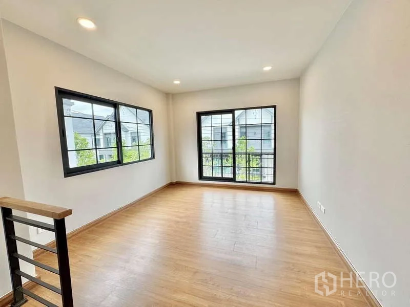 Detached House for sale in Bang Phli, Samut Prakan - Upstairs family area with wood flooring and large windows for natural light.