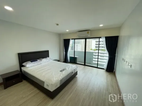 คอนโด ให้เช่าหรือขายในWatthana, Bangkok - ห้องนอนกว้าง เตียงคิงไซซ์ พื้นไม้ ประตูบานเลื่อนออกสู่ระเบียงชมวิวสกายไลน์กรุงเทพฯ