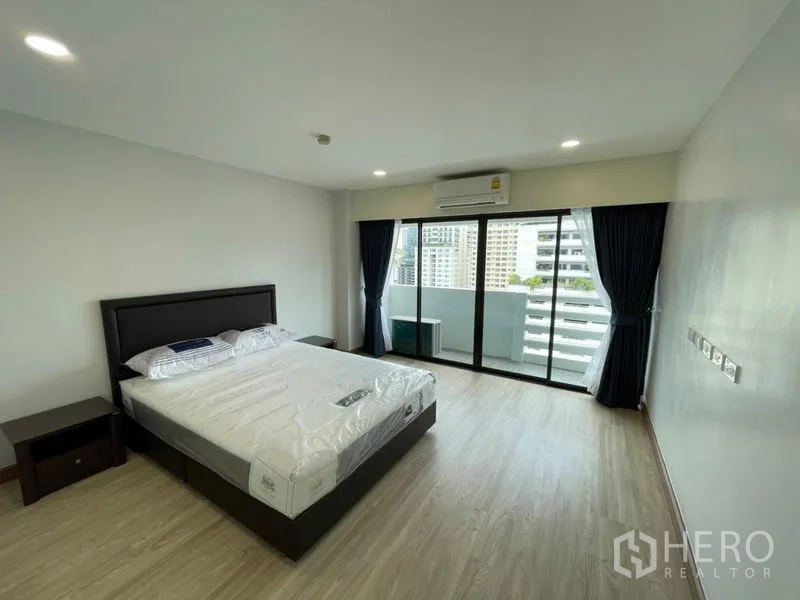 คอนโด ให้เช่าหรือขายในWatthana, Bangkok - ห้องนอนกว้าง เตียงคิงไซซ์ พื้นไม้ ประตูบานเลื่อนออกสู่ระเบียงชมวิวสกายไลน์กรุงเทพฯ