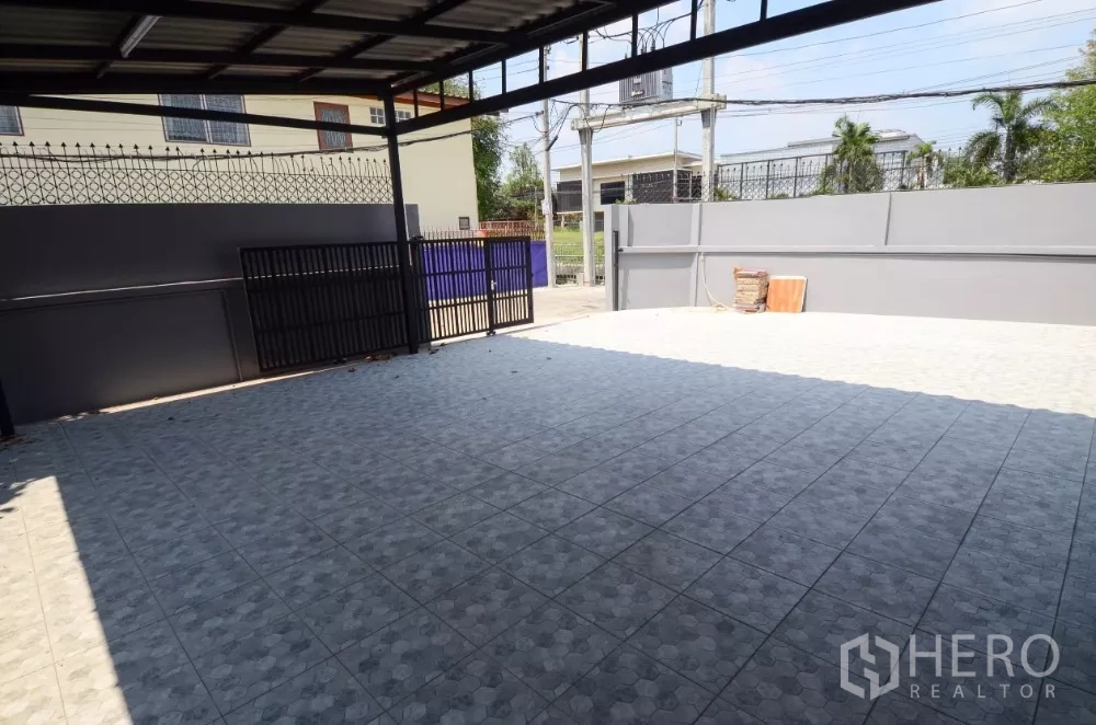 สำนักงานที่บ้าน ให้เช่าในLat Phrao, Bangkok - มุมมองจากโรงจอดรถไปยังถนน มีประตูรั้วสองชั้นและกำแพงสูง