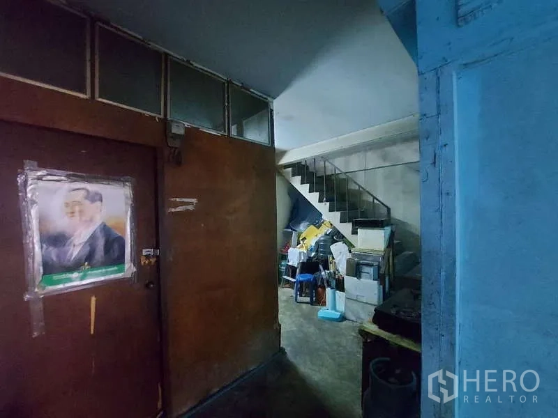 ทาวน์เฮาส์ ให้เช่า - โถงทางเดินมืดกั้นผนังไม้ มีของเก็บและบันไดขึ้นชั้นบน