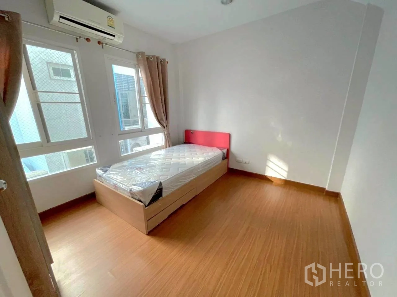 联排别墅 for rent in Bang Kho Laem, Bangkok - 卧室配单人床、木纹地板、空调与带窗帘的窗户。