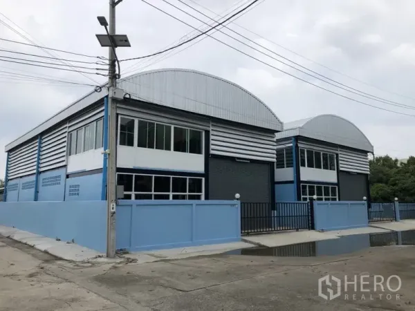 工厂 出租或出售在Bang Bua Thong, Nonthaburi - 一排新建仓储型工厂，弧形屋顶，临街带大门与围栏的前院。