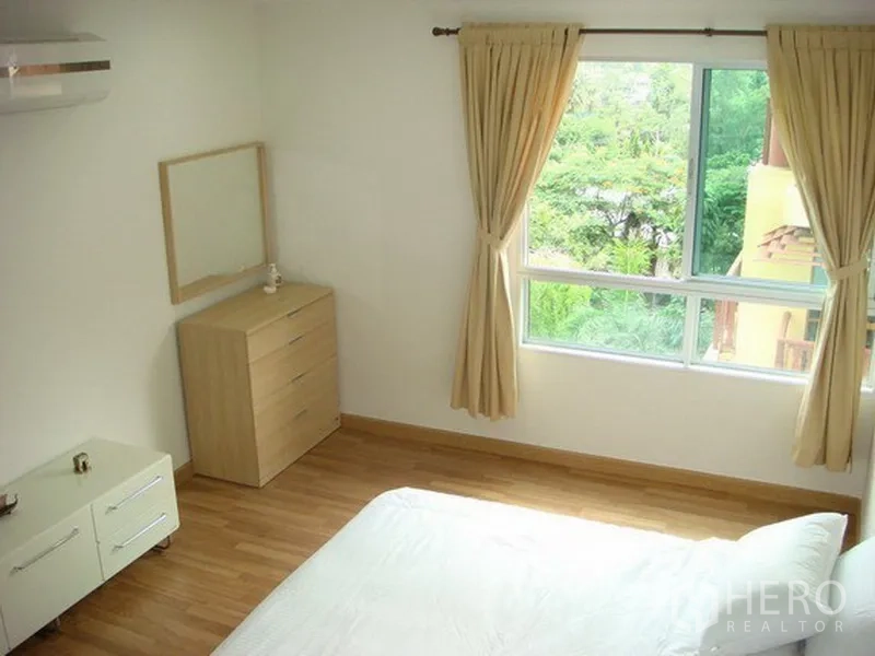 อพาร์ทเมนท์ ให้เช่าในRatchathewi, Bangkok - ห้องนอนมุมพร้อมหน้าต่างสองด้าน มีตู้ลิ้นชักและแอร์ มองวิวสีเขียว