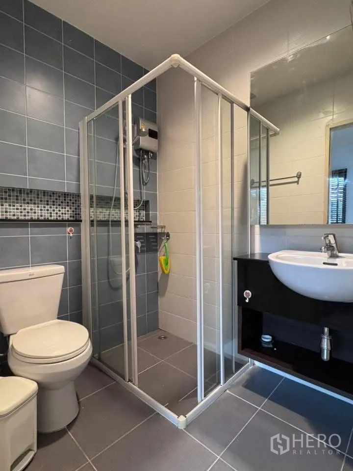 联排别墅 for rent in Phra Khanong, Bangkok - 卫生间设玻璃淋浴间、盥洗台与坐便器。