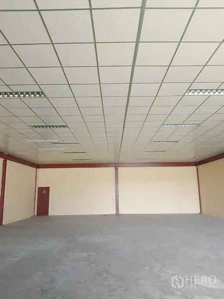 货栈 出租在Mueang Samut Prakan, Samut Prakan - 宽敞空旷的仓库大厅，无柱空间，格栅天花与日光灯照明。