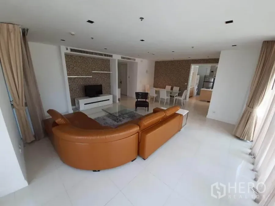 คอนโด ให้เช่าในPathum Wan, Bangkok - พื้นที่นั่งเล่นและรับประทานอาหารแบบโอเพนแปลน สว่างโปร่ง โซฟาหนัง ทีวี และหน้าต่างบานใหญ่ในคอนโดกรุงเทพฯ