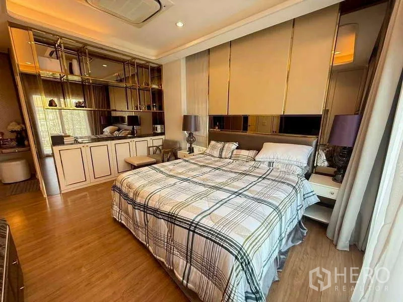 独立式住宅 出售在Bang Khen, Bangkok - 主卧配大床，暖色灯光，内置柜架与木地板。