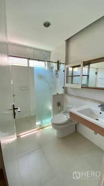 Detached House for rent in Bang Kapi, Bangkok - Clean bathroom with walk-in shower, glass partition and white tiles.