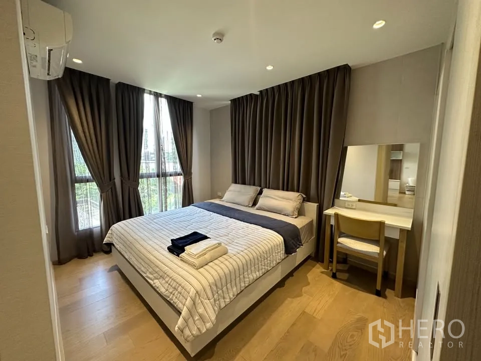 公寓 for rent in Watthana, Bangkok - 卧室配大床、落地窗、深色遮光窗帘与梳妆台。