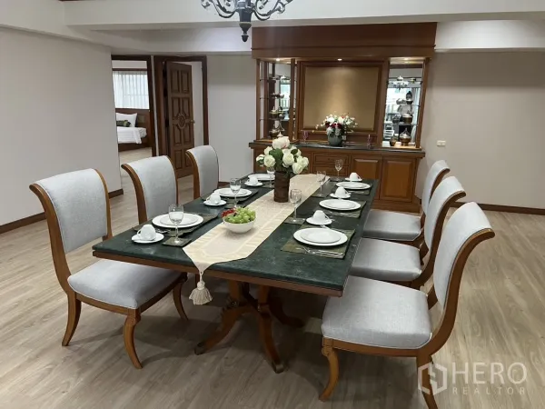 คอนโด ให้เช่าในKhlong Toei, Bangkok - ห้องรับประทานอาหารแบบเป็นทางการ โต๊ะ 8 ที่นั่ง ตู้ไม้บิวท์อิน และโคมไฟระย้าในคอนโดกว้างขวาง