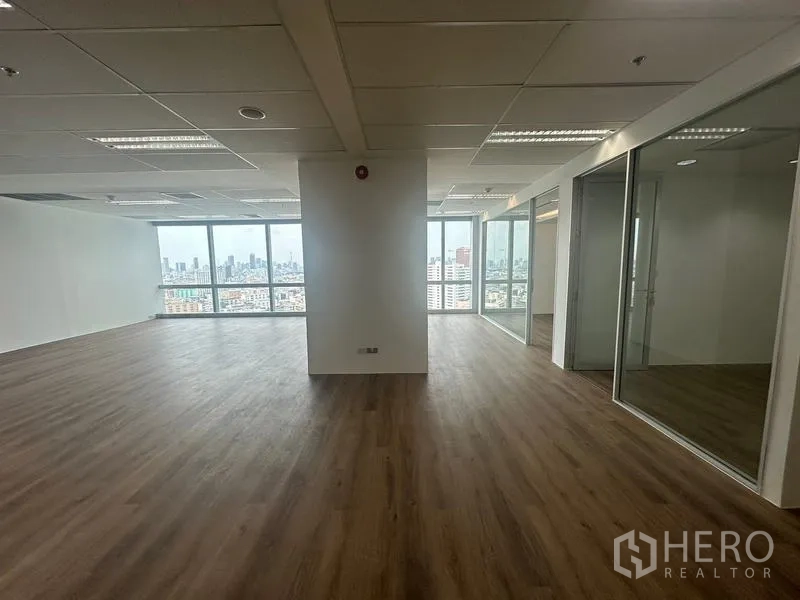 สำนักงาน ให้เช่า - สำนักงานโล่งมีเสากลาง ผนังกระจกด้านขวา และวิวเมืองด้านหน้า.