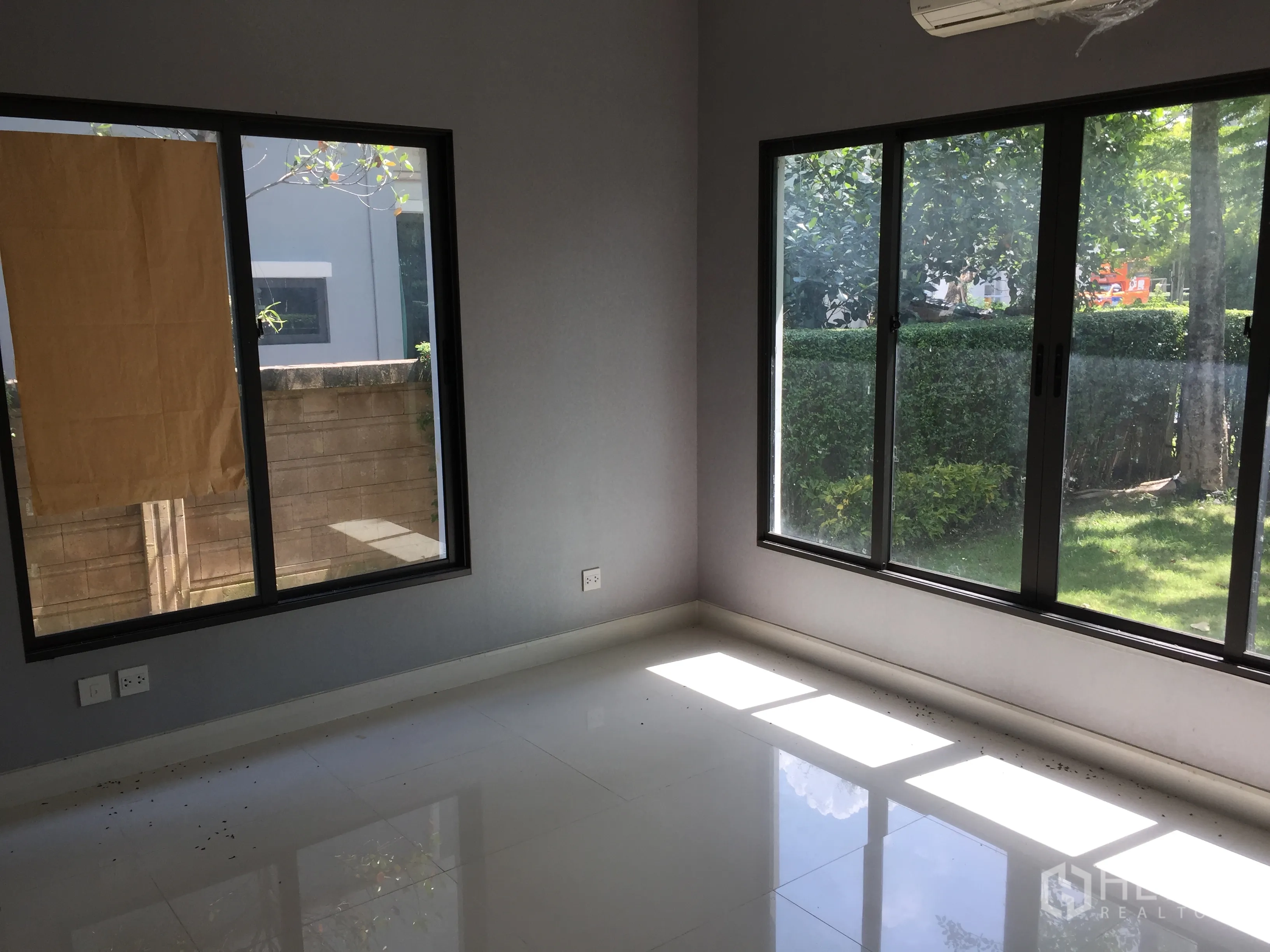 Detached House for rent or sale in Bang Kapi, Bangkok - Ground-floor bedroom with dual-aspect windows overlooking the lawn.