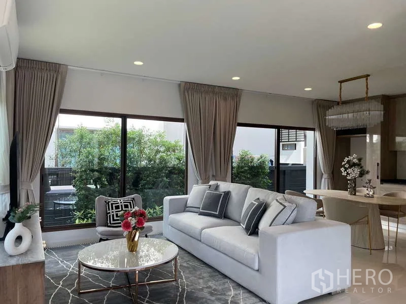 Detached House for rent in Bang Kapi, Bangkok - Bright open-plan living and dining area with large windows and garden views.