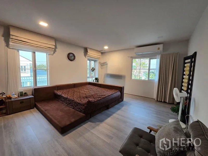 独立式住宅 出租在Bang Phli, Samut Prakan - 宽敞主卧，平台床，多扇窗与木地板。