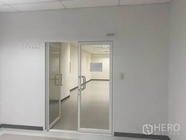 Office Space for rent in Bang Na, Bangkok - Glass double-door entrance to the office suite with bright neutral walls.