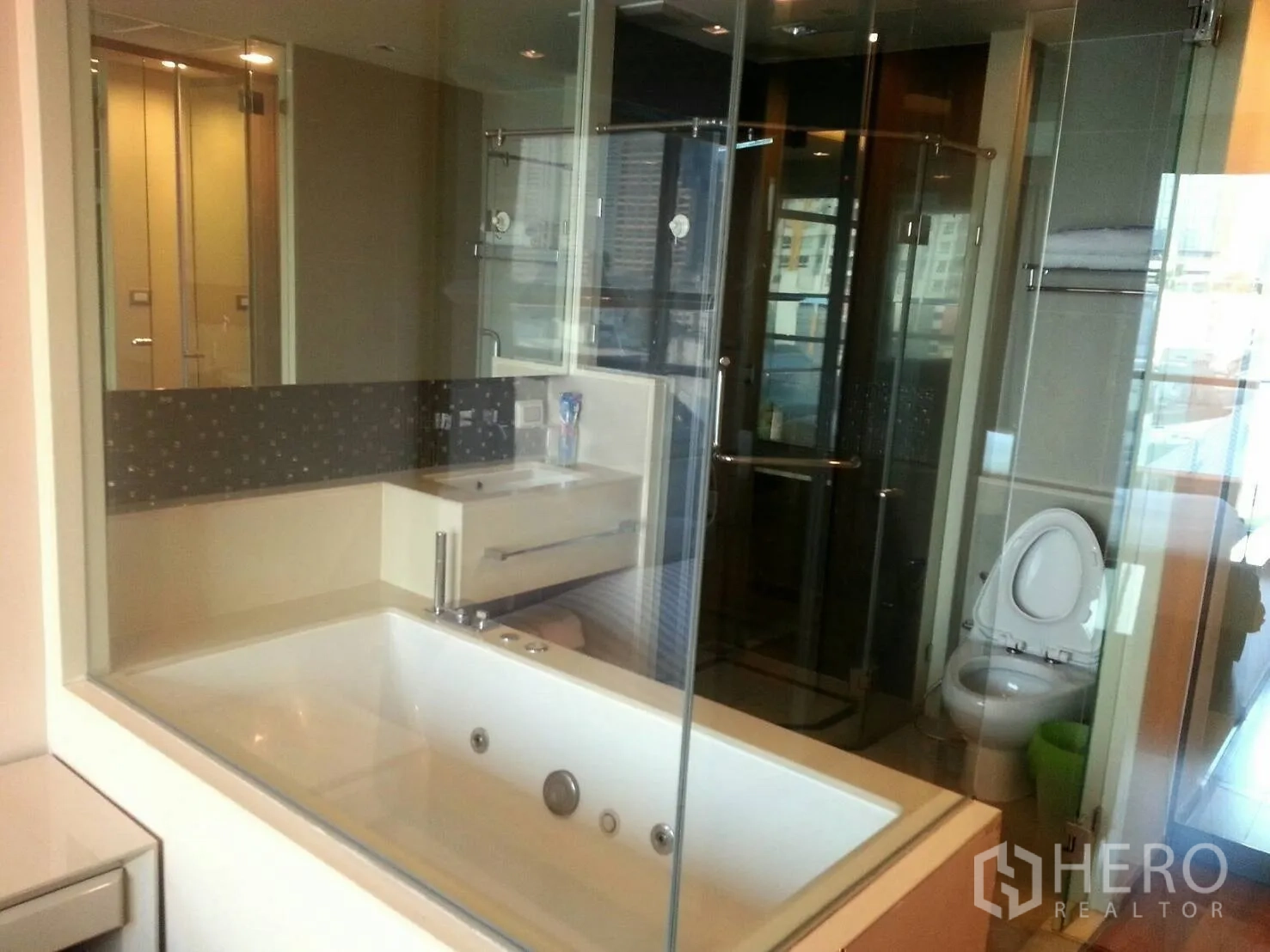 Condominium for rent or sale in Bang Rak, Bangkok - Master bathroom with jacuzzi bathtub and glass partition to shower and toilet.
