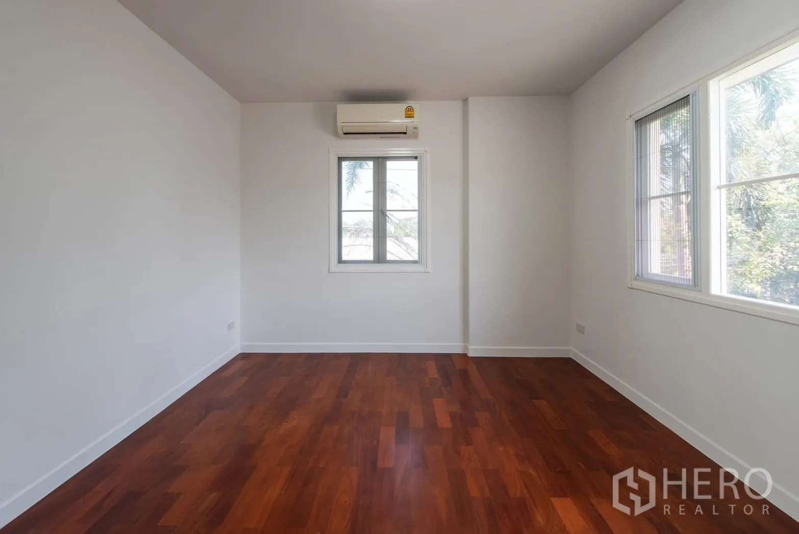Detached House for sale in Bang Phli, Samut Prakan - Bright bedroom with wood floor, white walls, window and wall-mounted air conditioner.